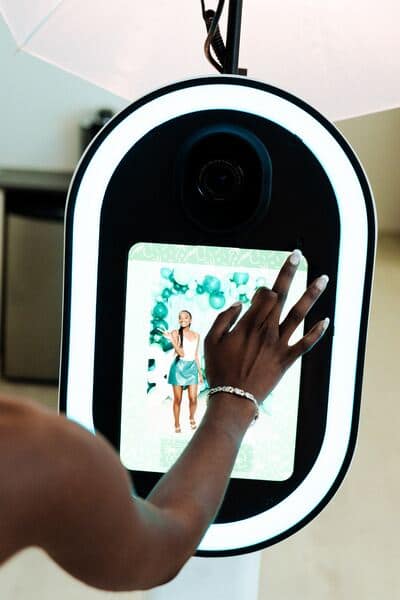 a lady clicks on the photobooth screen to adjust an image